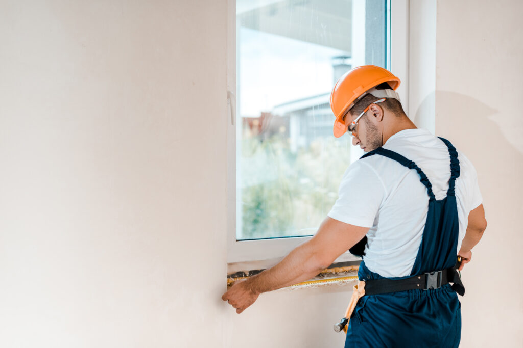 Construction man measuring a window